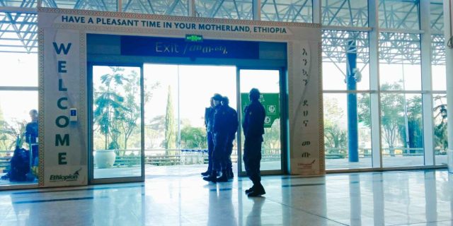Image of the exit sliding doors at bole international airport with a large banner at the side saying "WELCOME" And another one at the top saying "Have a pleasant time in your motherland, Ethiopia".