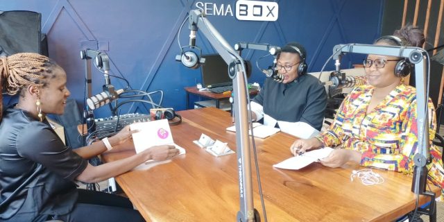 Liz Orembo, Anita Epalle and Mylline Anunda in a studio recording a podcast.