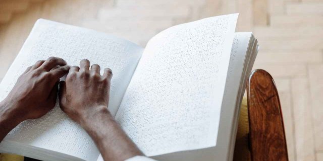 A Person Touching a Braille Book