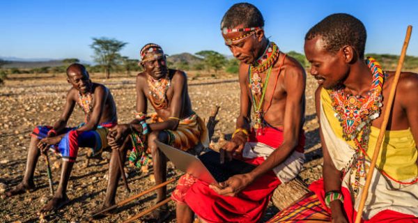 African warrior from Samburu tribe using laptop on savanna, central Kenya, Africa. Samburu tribe is one of the biggest tribes of north-central Kenya, and they are related to the Maasai.