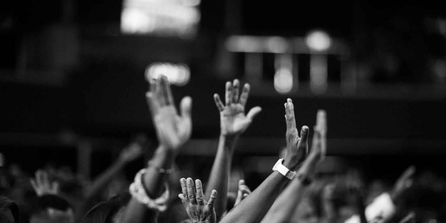 People in a forum raising their hands
