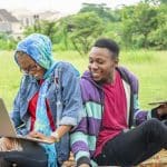 KICTANet Secures Two people using a computer and phone with a green scenery.