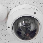 A Round White Cctv Camera on a white ceiling