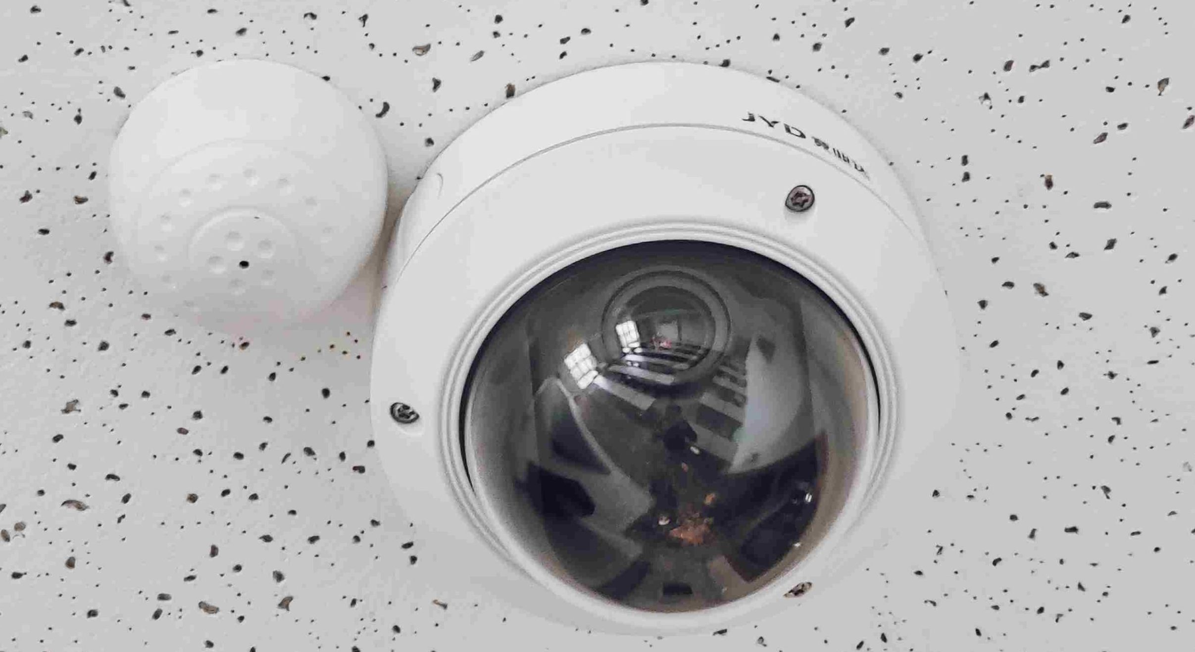 A Round White Cctv Camera on a white ceiling
