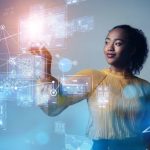A future realistic image of a lady pointing at a virtual screen.
